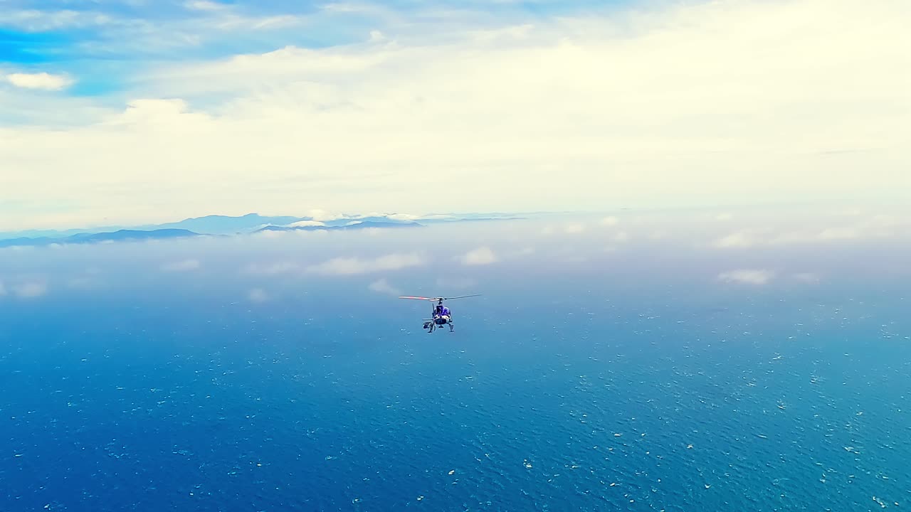 Helicopter flying over the Cook Strait ocean and white clouds towards the South Island of New Zealand