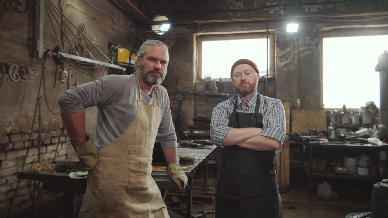 два кузнеца позируют для камеры в мастерской
