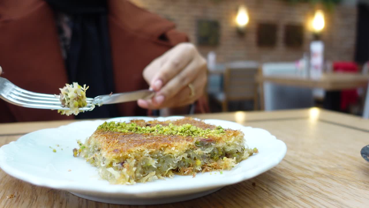 레스토랑 에서 피스타치오 와 함께 바클라바 를 먹는 여자 의 클로즈업