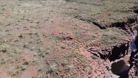 Drone-aerial-over-a-gorge-and-barren-landscape-in-Australia-on-a-sunny-day