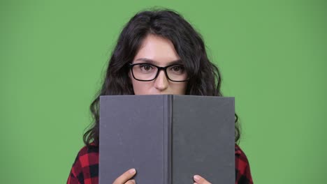 young beautiful businesswoman covering face with book