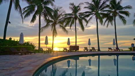 Sombrilla-Y-Silla-Alrededor-De-La-Piscina-En-El-Hotel-Resort-Para-Viajes-De-Placer-Y-Vacaciones-Cerca-De-La-Playa-Del-Océano-Al-Atardecer-O-Al-Amanecer