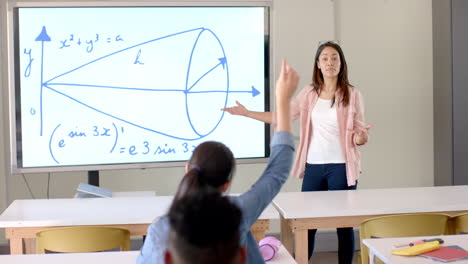 young biracial woman teaches in a high school classroom