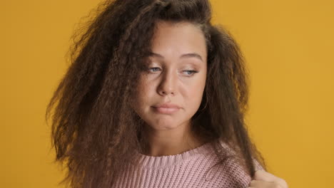 thoughtful caucasian curly haired woman in front of the camera.