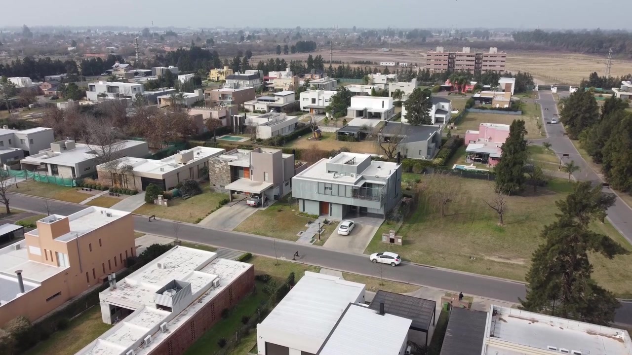 Una vista aérea de una calle suburbana con coches aparcados a un lado.