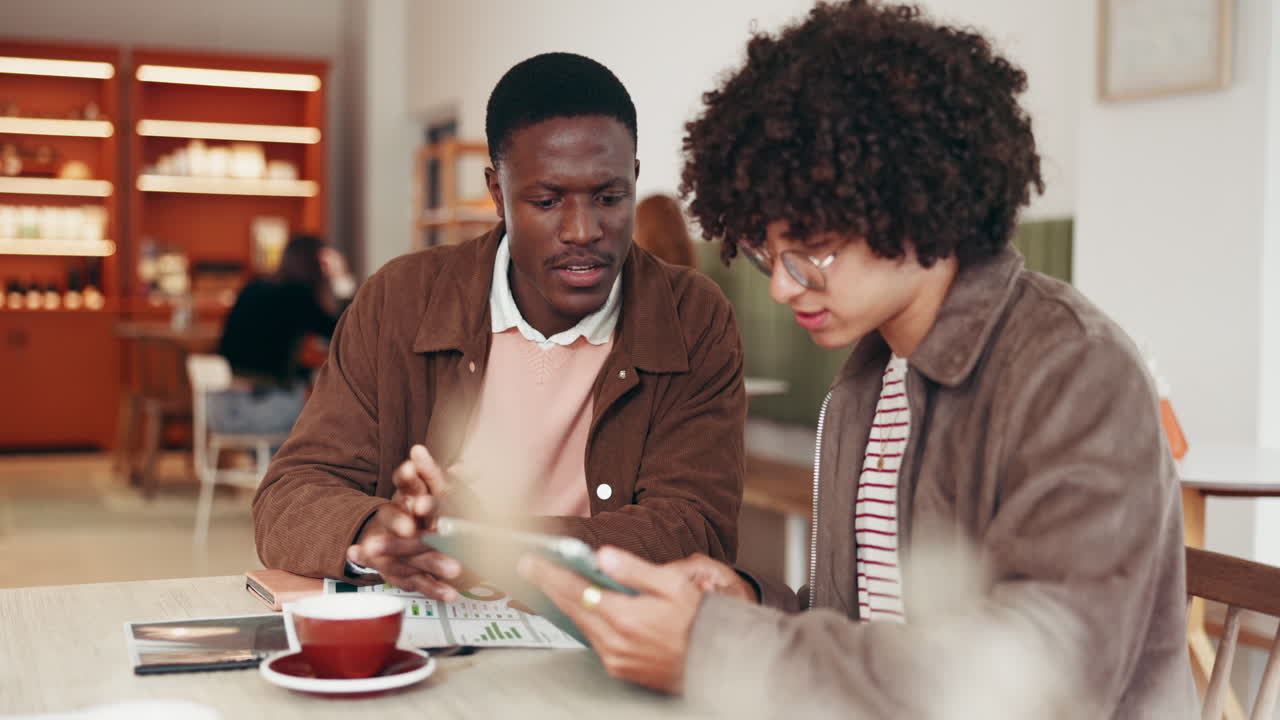 Two Young Businessmen Meeting in a Cafe