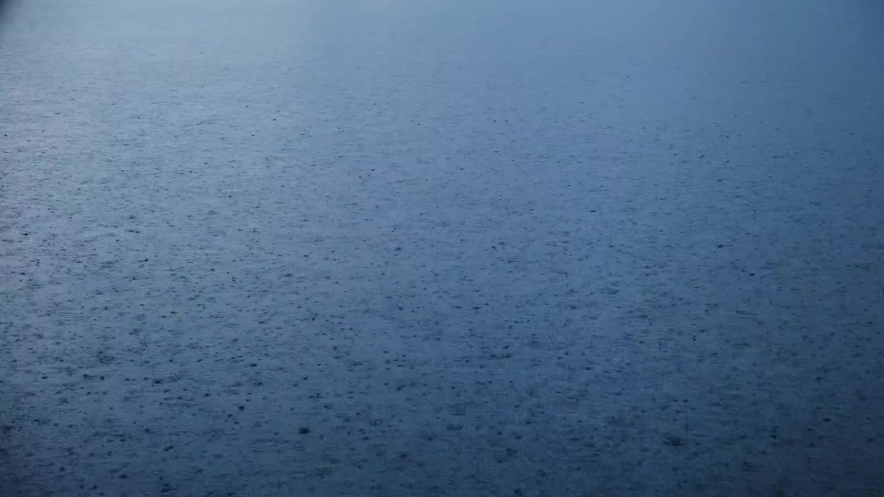 Calm, misty blue ocean surface. Gentle ripples move slowly across the water. Soft light fades from horizon to sea. Ideal for backgrounds, meditations, or travel videos