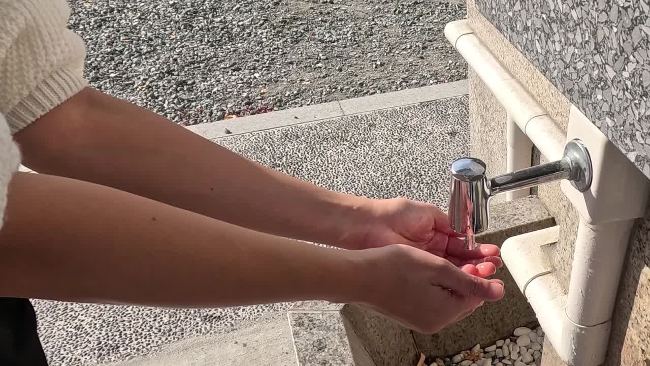 Lavarsi le mani a una fontana pubblica.