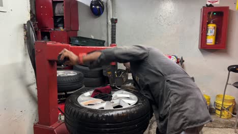 mechanic fixing a car wheel in workshop