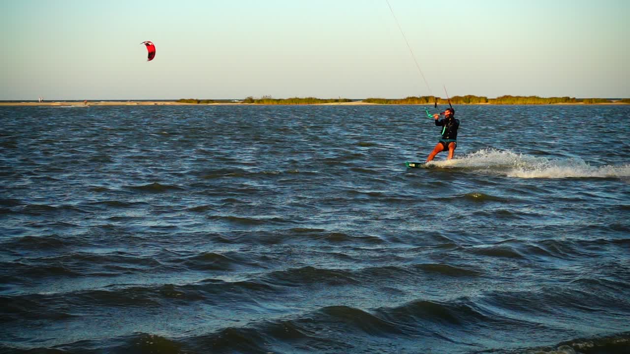 Kitesurf. Câmera lenta. Pôr do sol no mar. Esporte.