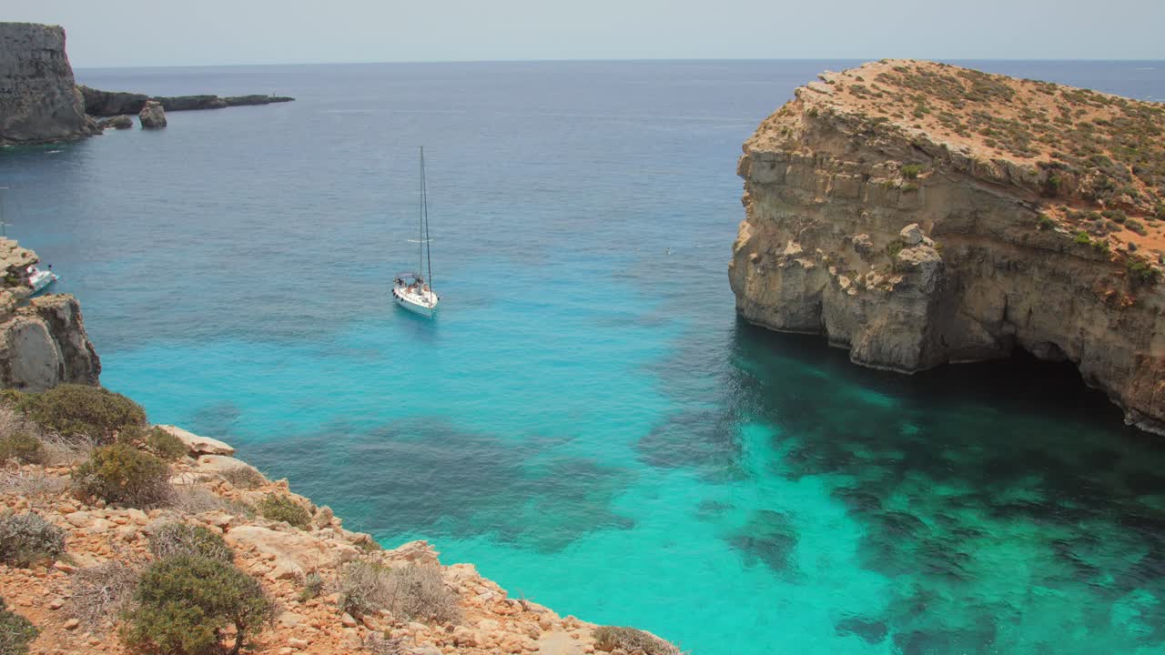맑고 푸른 바다가 있는 코미노 섬 절벽 근처의 범선