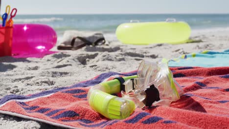 Video-De-Máscara-De-Snorkel,-Toallas-Y-Equipo-De-Playa-Tirados-En-La-Playa.