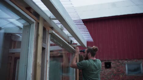 a man constructing a greenhouse in indre fosen, norway - close up