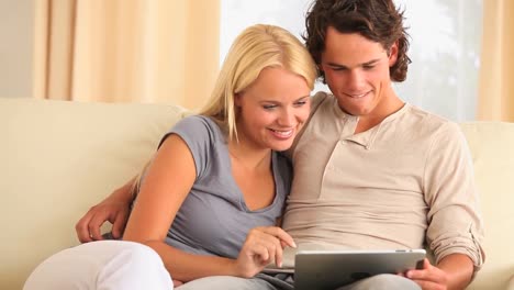 pareja en el sofá con una tableta