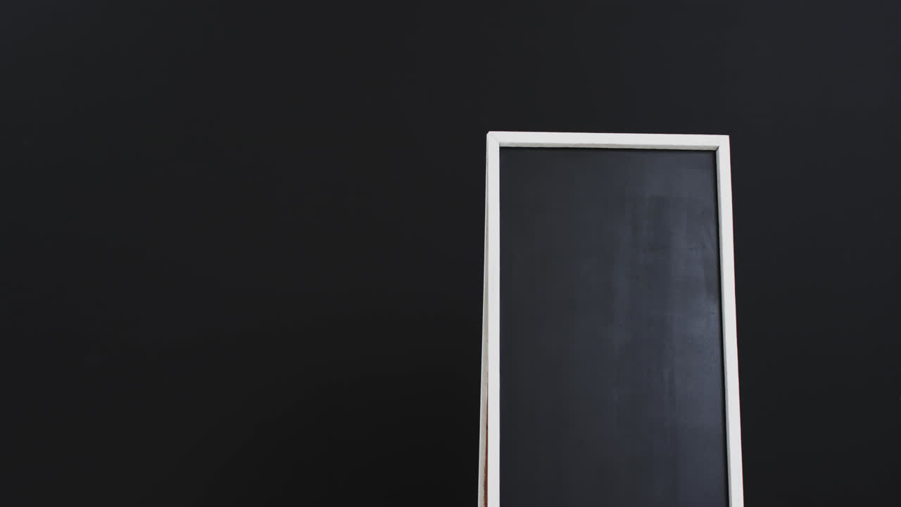 video de un letrero de pizarra en soporte blanco con espacio de copia en fondo negro