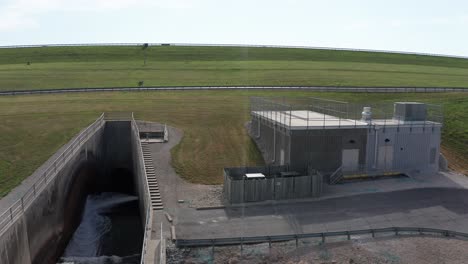 Aerial-close-up-panning-shot-of-the-Wakarusa-River-spillway-and-maintenance-utility-building-in-Kansas