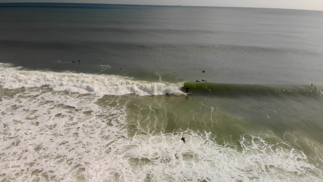 Spettacolare inseguimento con drone di un surfista che cavalca un'onda.