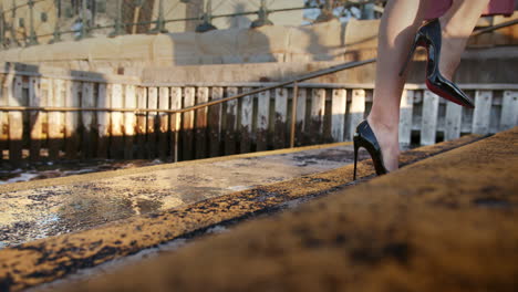 Die-Beine-Einer-Schönen-Frau-In-High-Heels-Gehen-Treppen-Hinauf,-Während-Im-Hintergrund-Wellen-Krachen