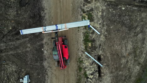 drone de arriba hacia abajo disparado por encima de una máquina que transporta material en un proyecto de parque solar