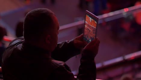 hombre viendo un video en una tableta en un evento