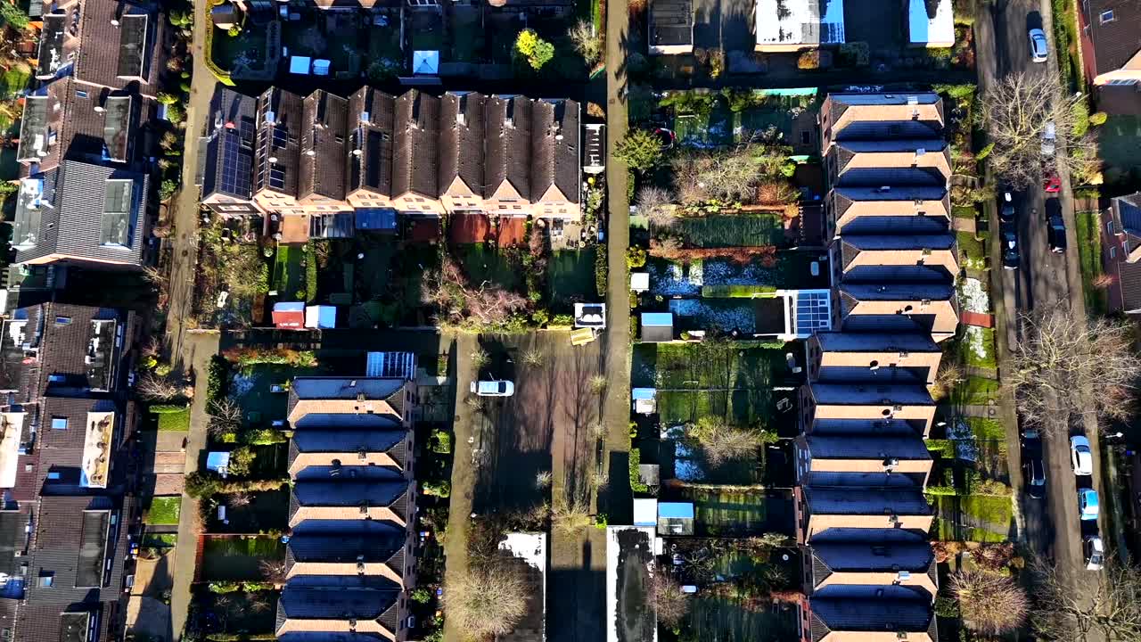 Charming snowy Suburb of historic american town during sunny day in winter season. Townhouses and row of homes in quaint district of USA. Aerial top down flyover shot. Serene atmosphere scene.