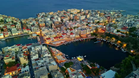 rotating aerial view of agios nikolaos city during evening in crete island, greece.
