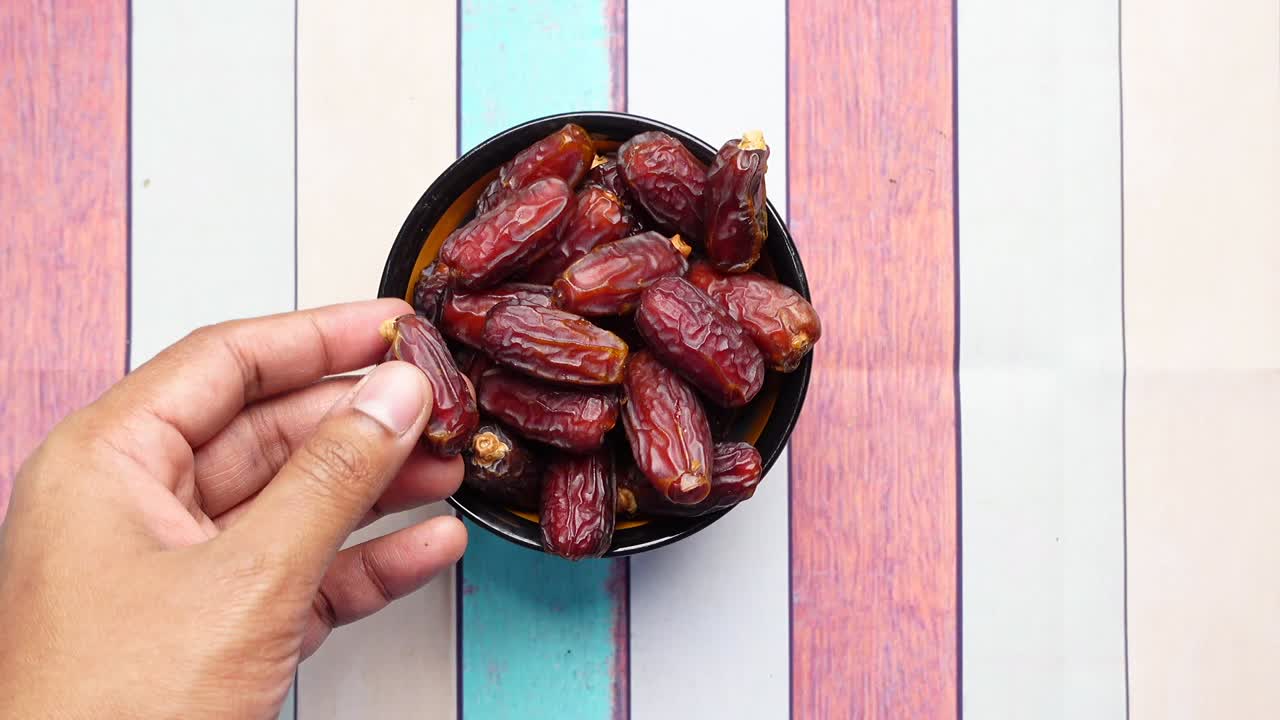 man reaching for date fruits on table