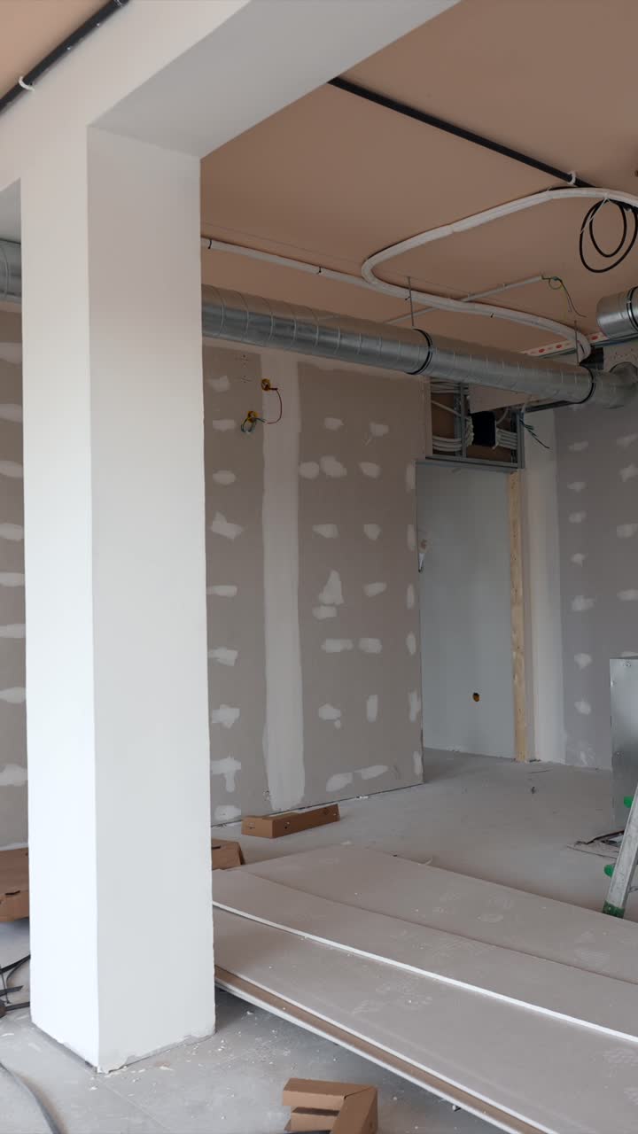 Interior de um Cômodo Inacabado com Drywall, Dutos de Ventilação e Materiais de Construção