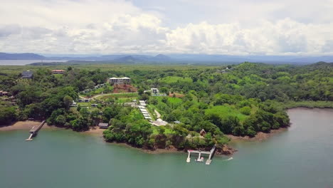 horizontal drone shot of beautiful vacation location next to the sea in a forest with mountain and cloudy sky background, boca, chica, panama