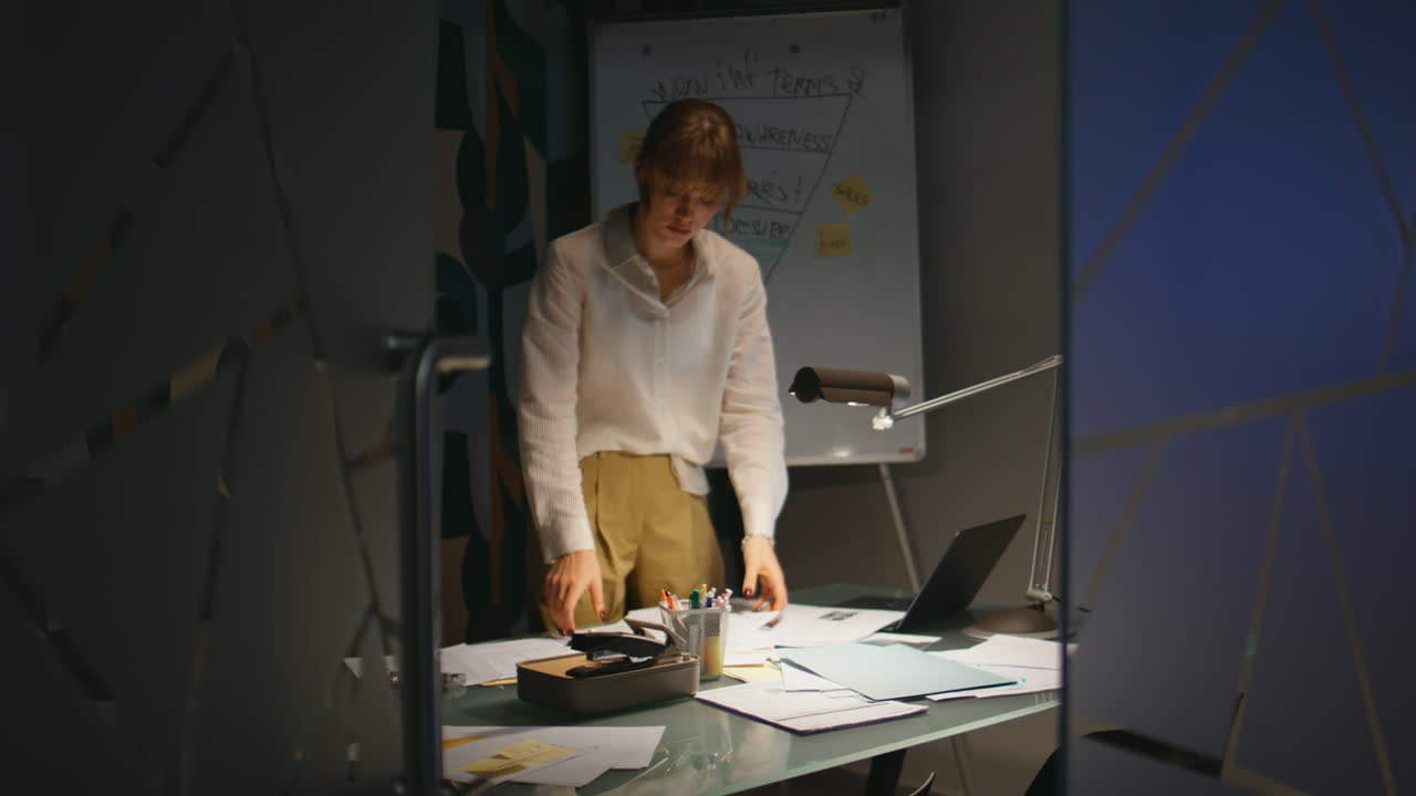 Imprenditrice a fine giornata lavorativa nel suo ufficio privato. Signora seria che spegne la luce