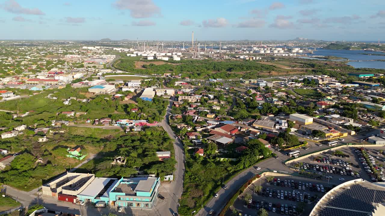 드론은 멀리 있는 정유소의 전망으로 쿠라카오 이웃을 밀어 넣습니다.