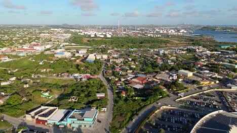 drone push in over curacao neighborhood with view of refinery in distance