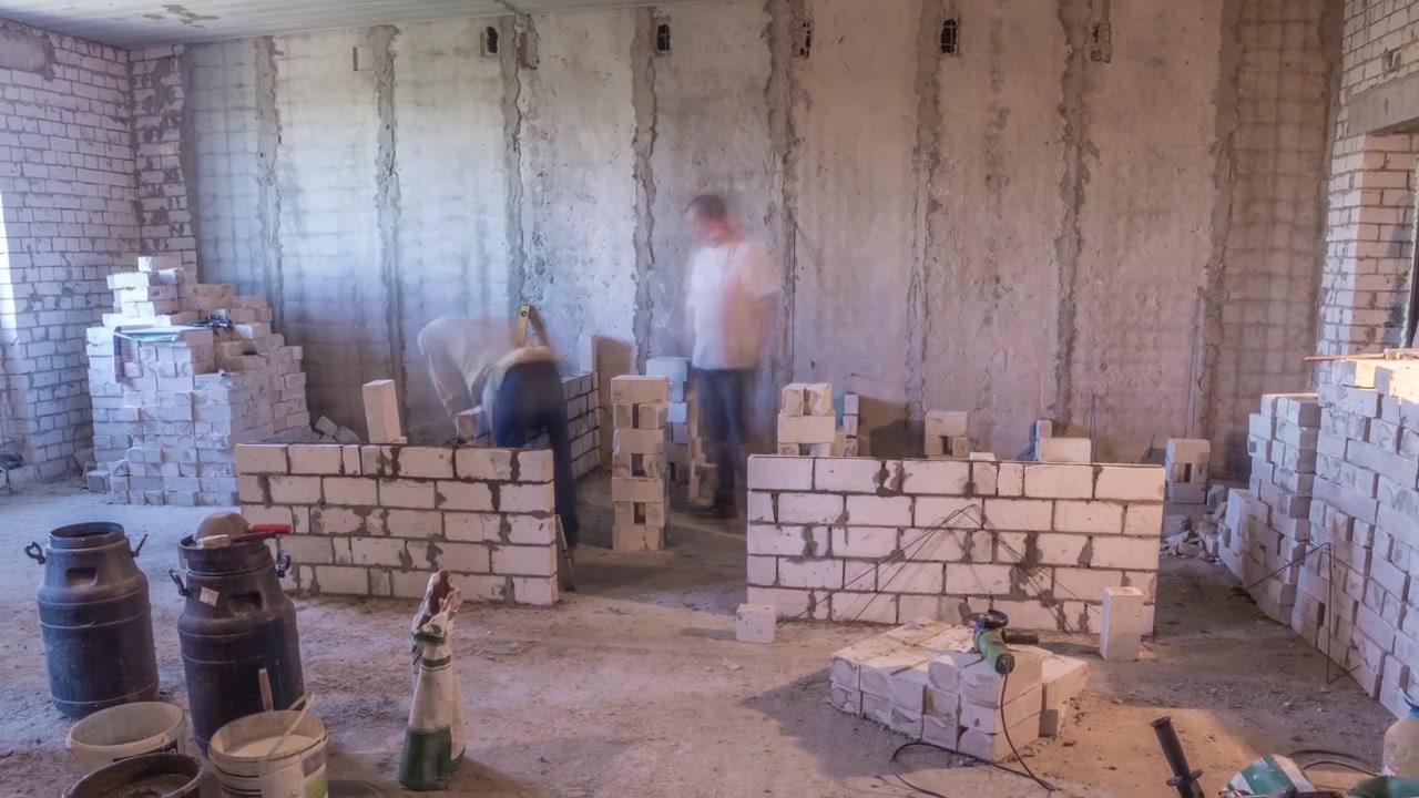Construtores assentando paredes de tijolos dentro de apartamento com ferramentas profissionais em timelapse. Trabalhadores em ação, pedreiros construindo parede, empreiteiro e operário. Materiais de construção ao redor