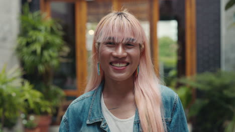 smiling transgender person in outdoor cafe