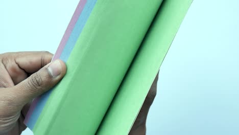 cerca de la mano de un hombre girando un buscapersonas de un diario