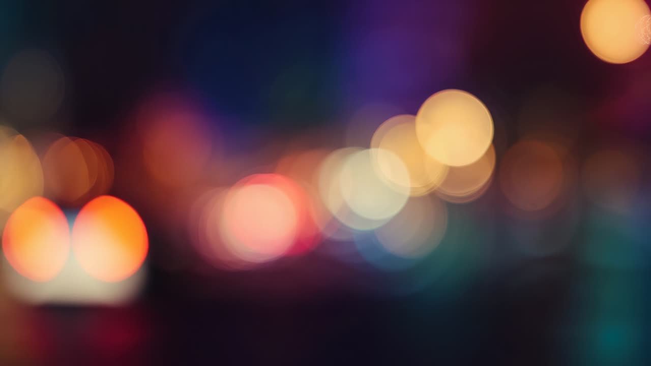 Focusing camera capturing defocused urban light bokeh at night, showing colored light points