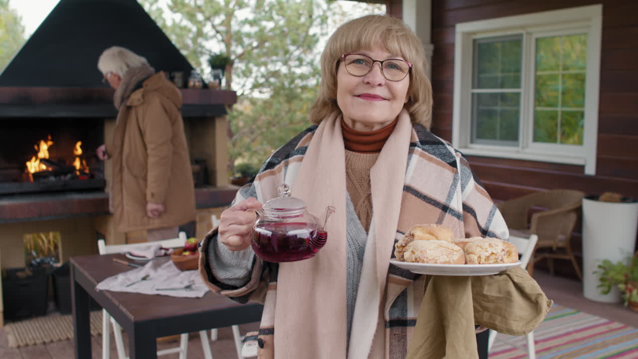 Senior Woman Serving Tea and Food Outdoors
