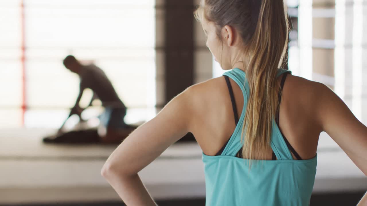 video de la vista de atrás de una mujer caucásica en forma en el gimnasio