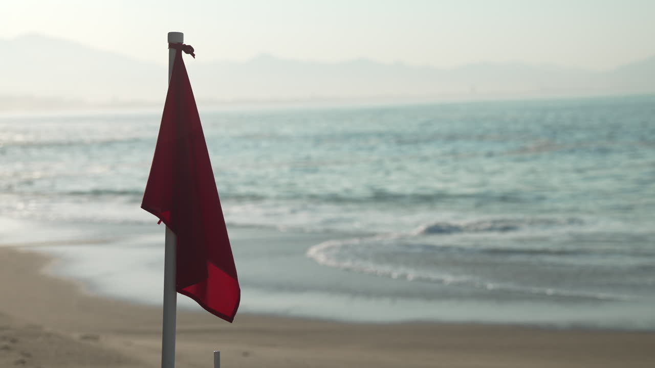 Red flag at the beach warning of high hazard, dangerous surf, strong currents, use extreme caution