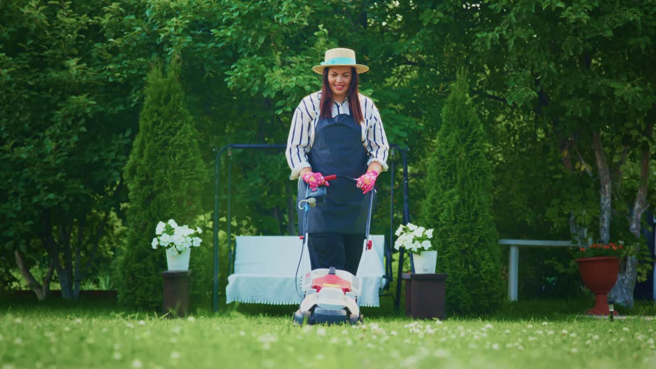 Woman mowing the lawn in a garden
