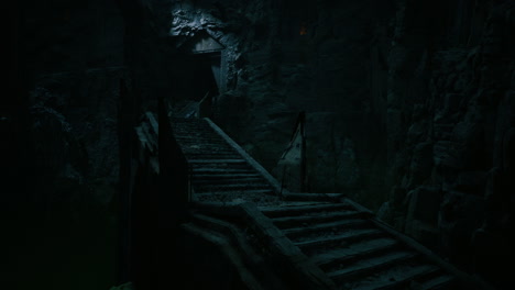 mysterious staircase leading into a dark cave in a rocky landscape