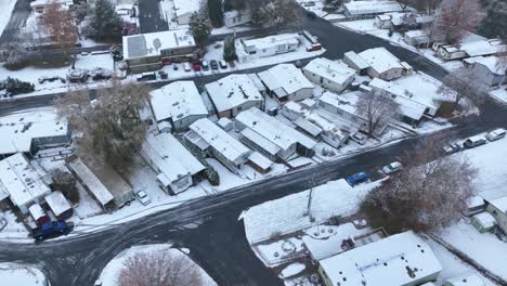 vista aérea de arriba hacia abajo de un parque de casas móviles cubierto de nieve