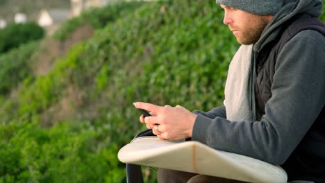 side view of mid-adult caucasian man texting on mobile phone near seaside 4k