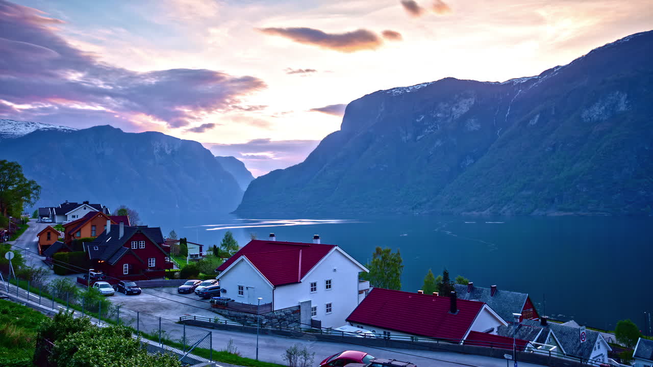 timelapse del atardecer sobre un pequeño pueblo noruego con los fiordos de aurlands al atardecer