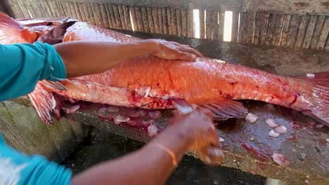 Cerrar-Las-Manos-Del-Hombre-Trabajando-Cortar-Y-Abrir-Pescado-Cubera-Pargo-Largo,-Mercado-De-Pescado-Callejero