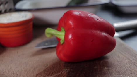 deslizamiento lento de derecha a izquierda del pimiento rojo sobre una tabla de cortar de madera