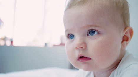 head and shoulders of happy baby boy lying on parents bed