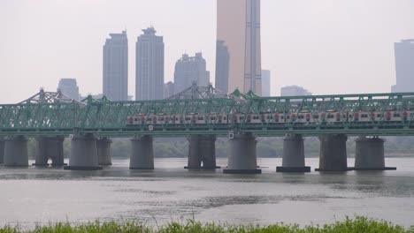 a train on the gyeongbu expressway travels over the han river in seoul