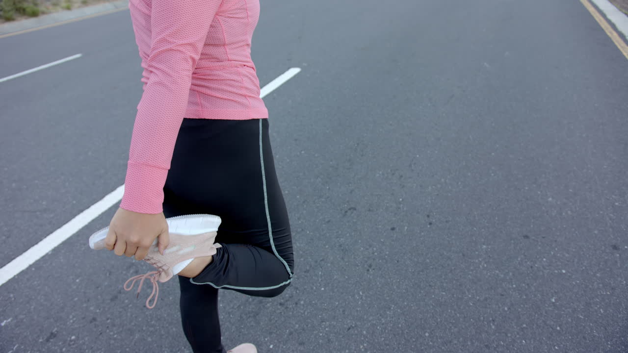 Stretching leg muscles, woman in athletic wear preparing for outdoor exercise, copy space