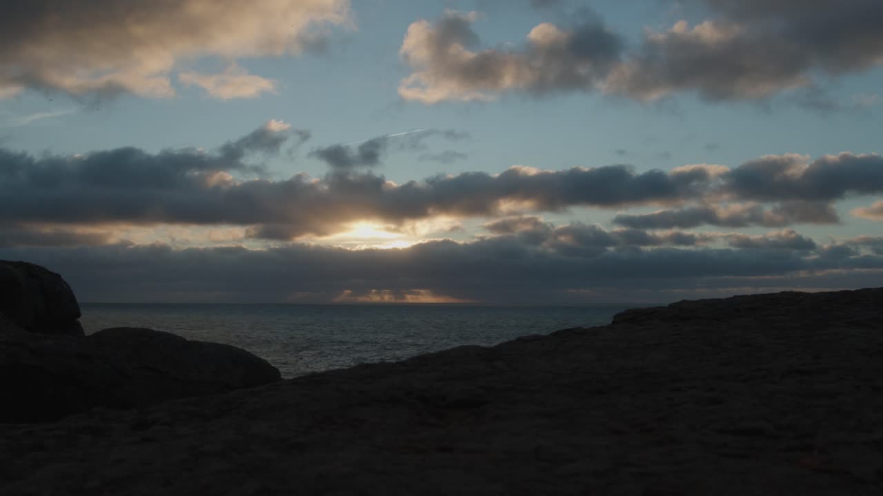 포르투갈의 북쪽 해변이나 프라이아 두 노르테의 시간 경과, 움직이는 구름과 태양이 아래로 떨어짐